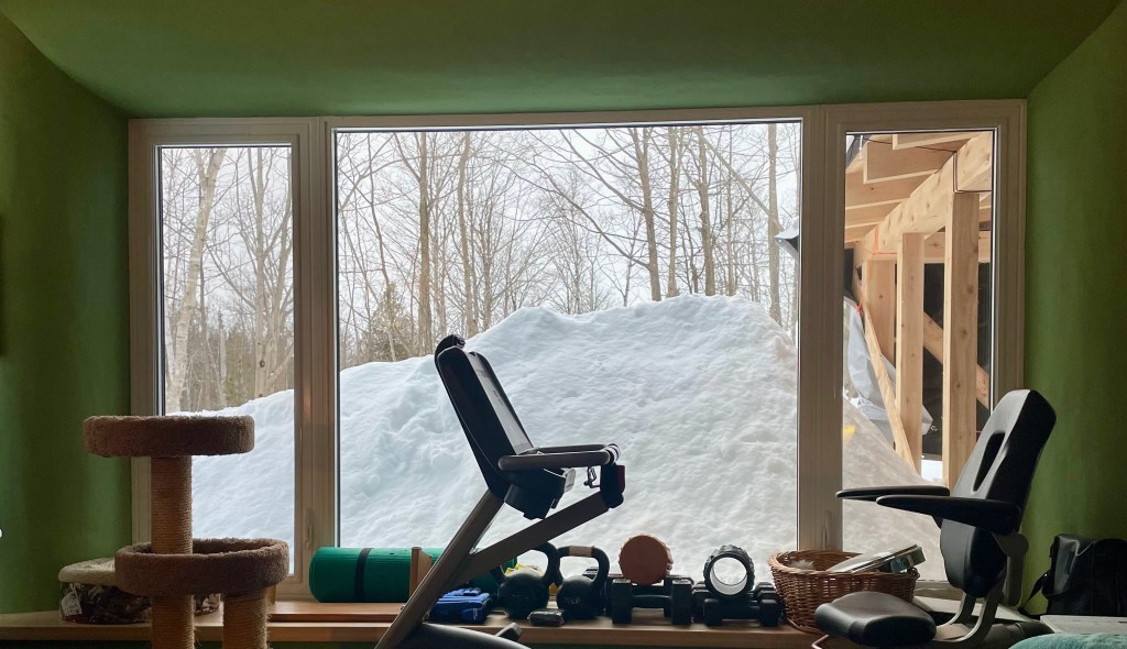 a snowpile obscuring a window.