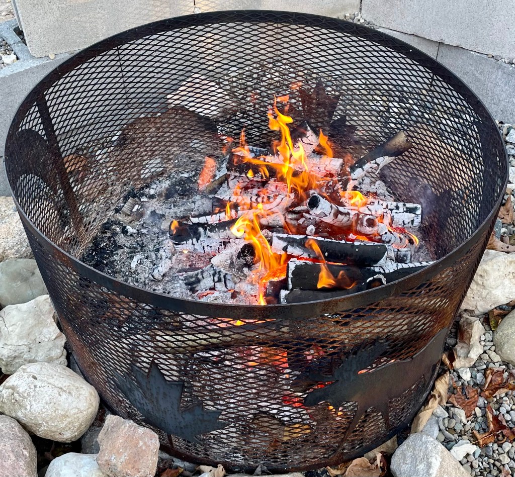 A campfire burning hardwood and manufacturing a lot of coals.