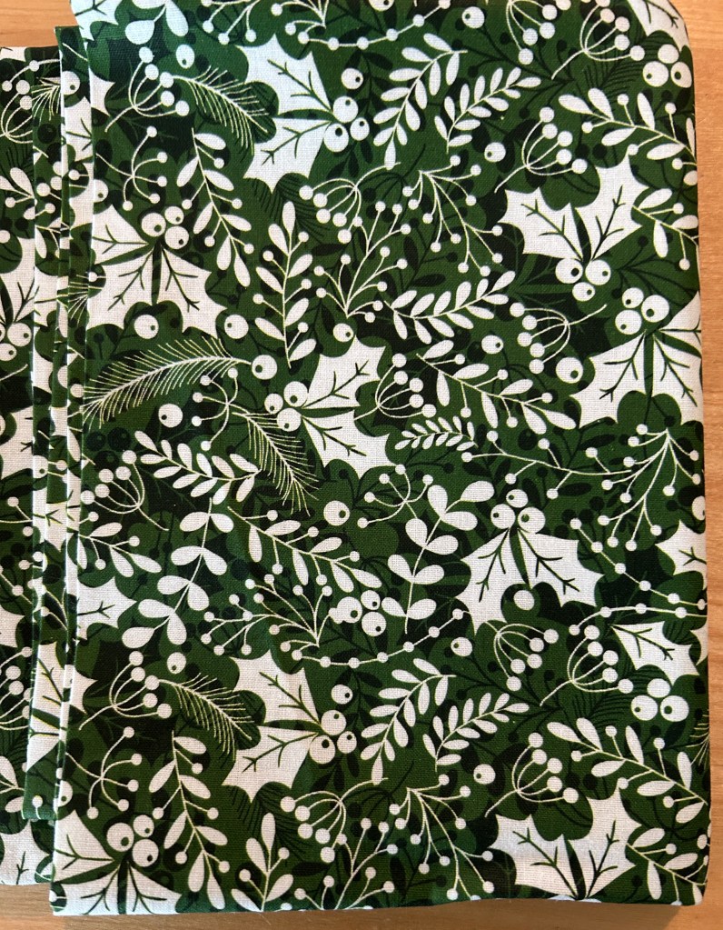Raw material for making catnip mouse toys. Green background and holly leaves.